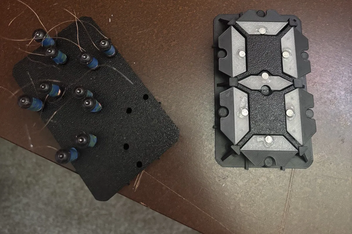 A 3D-printed seven-segment module with flip segments, next to a backplate of hand-wound electromagnet coils.